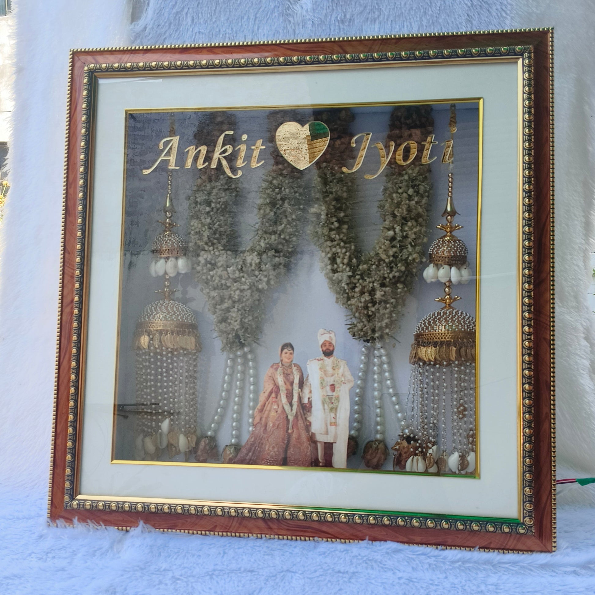 Custom handmade varmala preservation frame with couple photo, names, warm lights and preserved wedding flowers by Shaahi Decor.