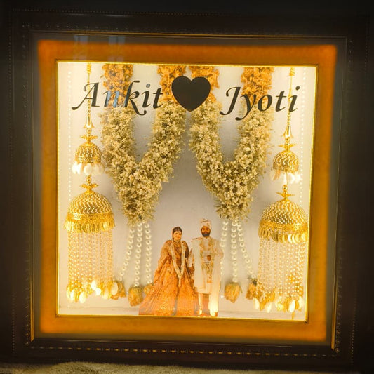 Custom handmade varmala preservation frame with couple photo, names, warm lights and preserved wedding flowers by Shaahi Decor.